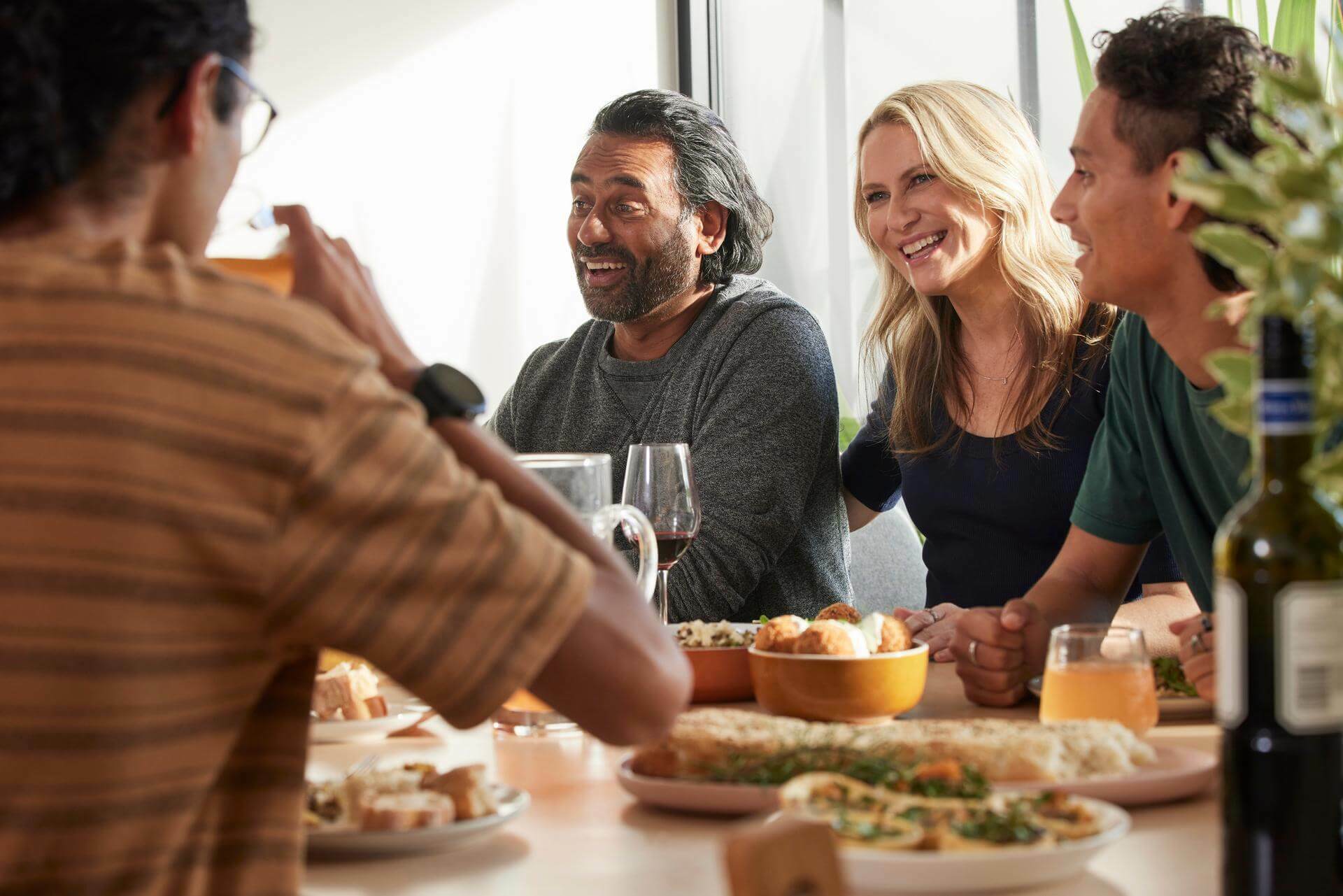 Friends talking and laughing at a dinner party