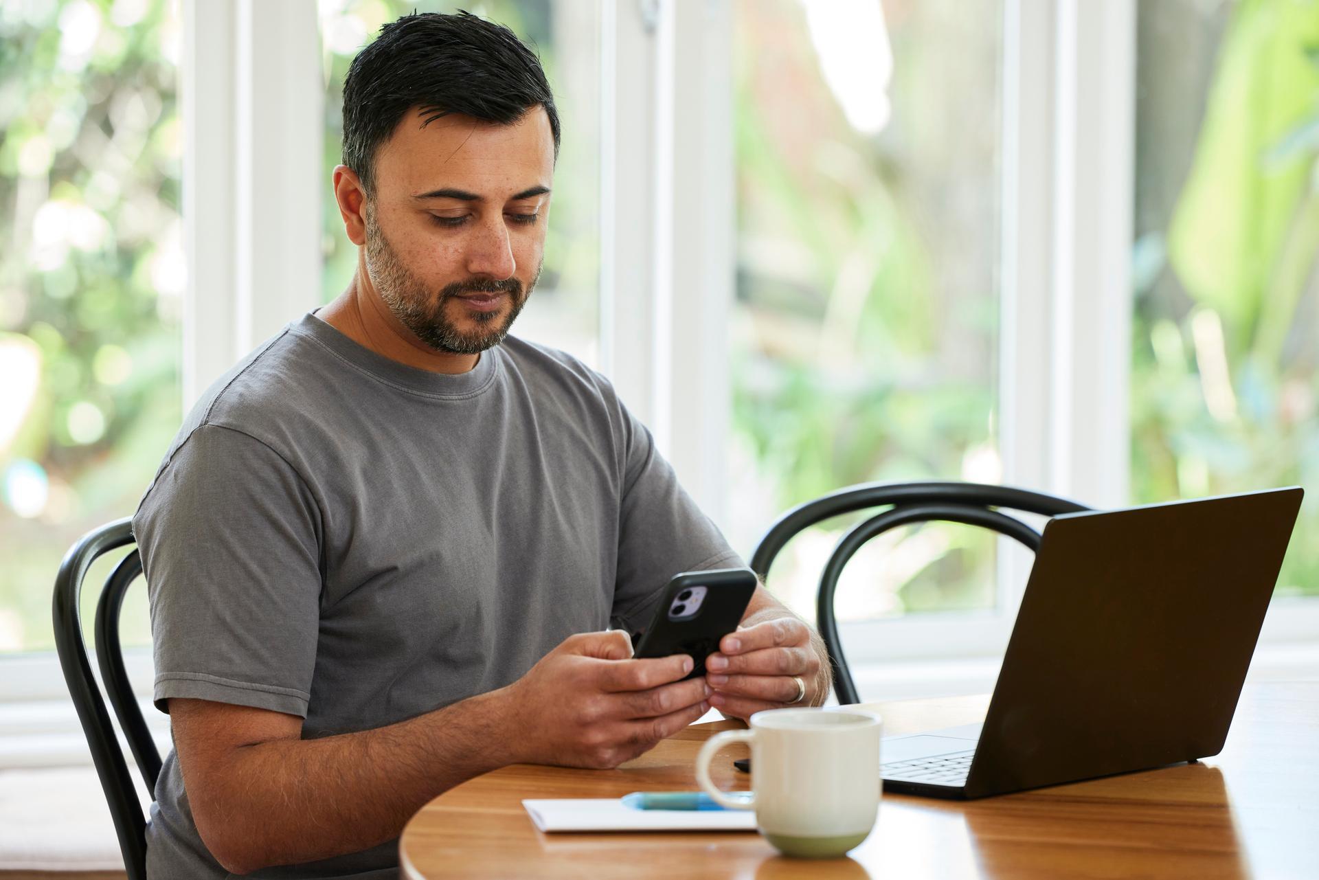 Man on phone in front of his computer