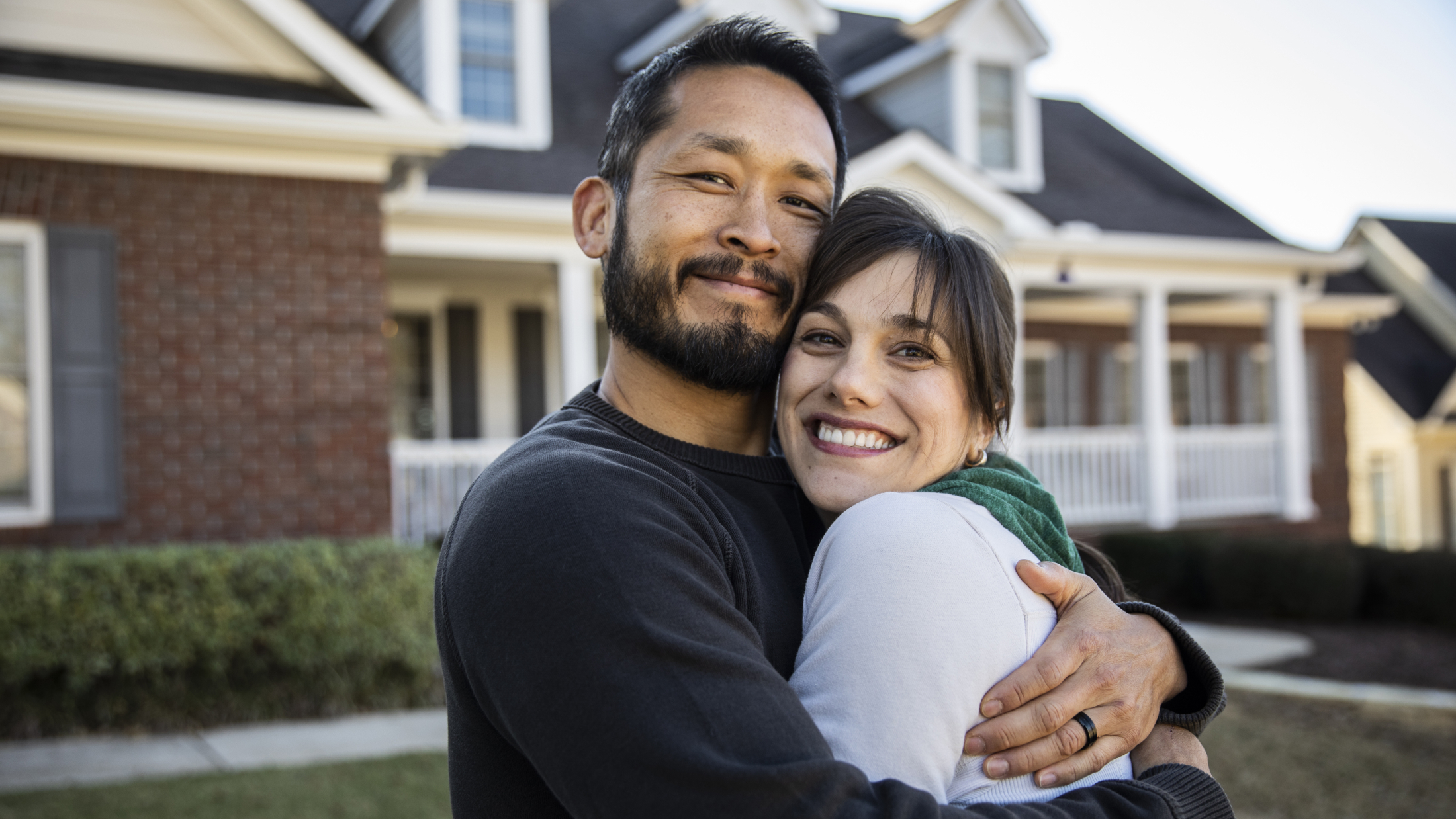 Man and woman hugging outside home