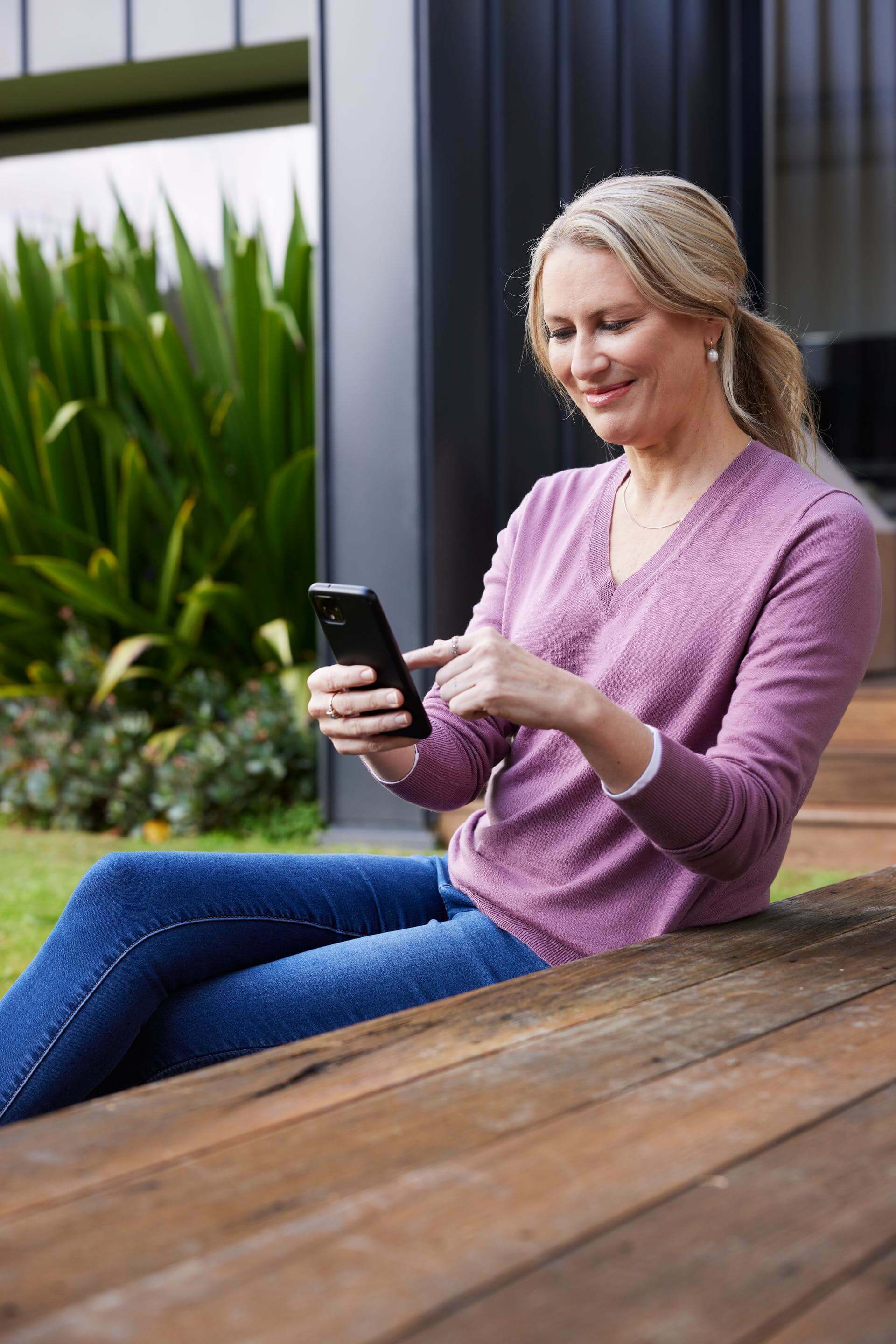 Woman sitting outside on her phone