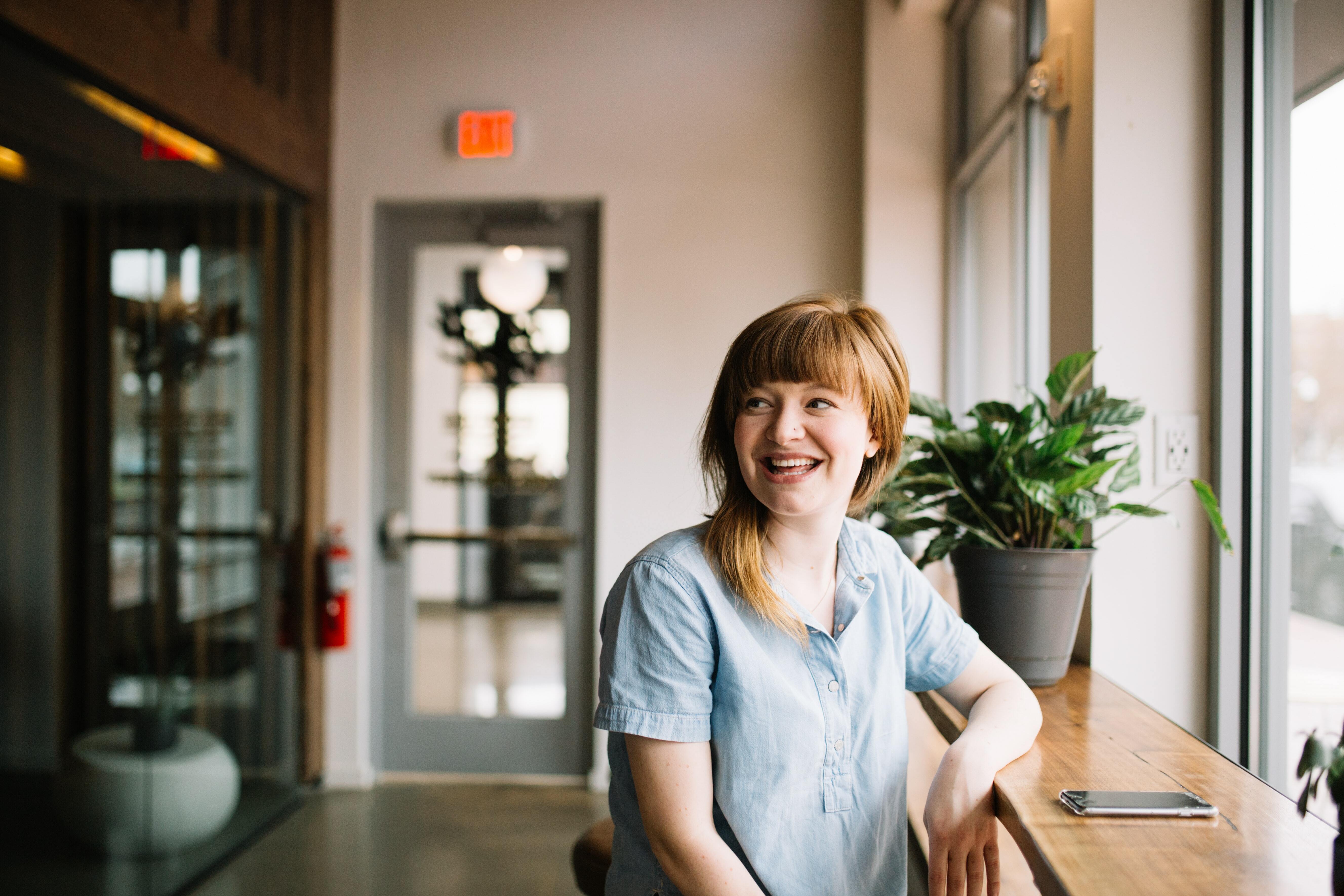 Woman sitting at bench in cafe smiling